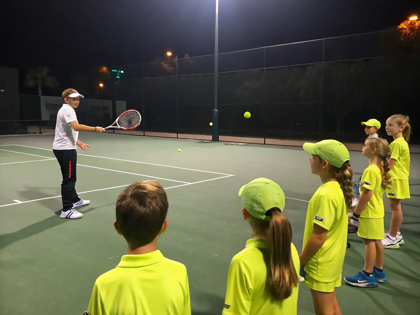 A vibrant image of adults participating in a tennis lesson on a sunny court, with a coach demonstrating proper technique.